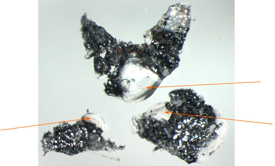 ФОТО 12. Частицы ЛКП с правой боковины в области наплыва (стрелками показаны микрочастицы, похожие на стекло) (увеличение 40х)