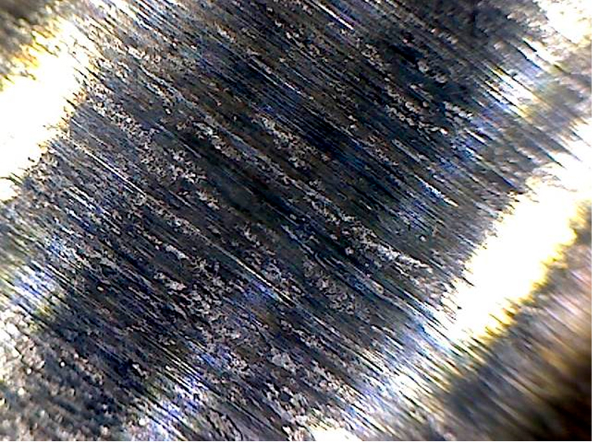 Фото 35. Износ кулачка с выкрашиванием металла зафиксирован по краям. Вид через микроскоп – увеличение в 10 раз