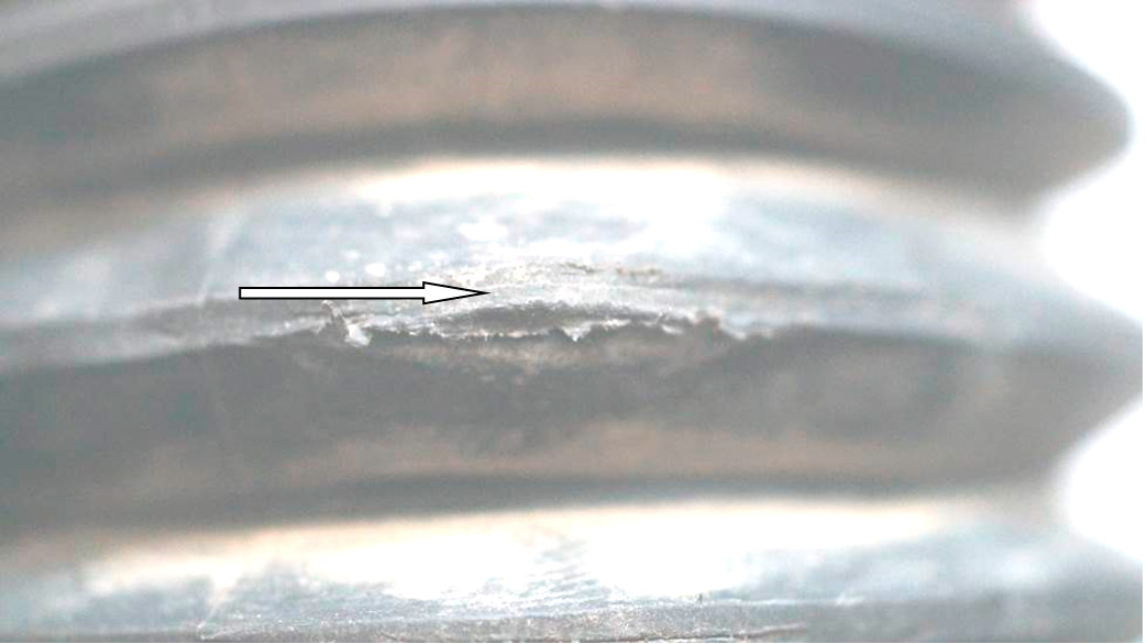 Фото 26. Место, локализованное вокруг трещины, имеет задиры резины (показано белой стрелкой).