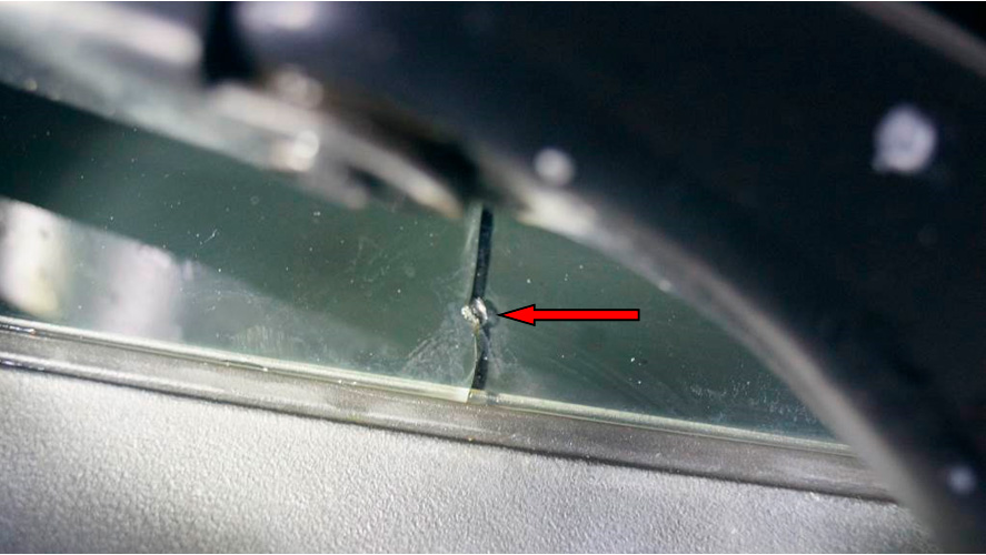 Фото 16. Месторасположение скола на стекле (показан красной стрелкой).