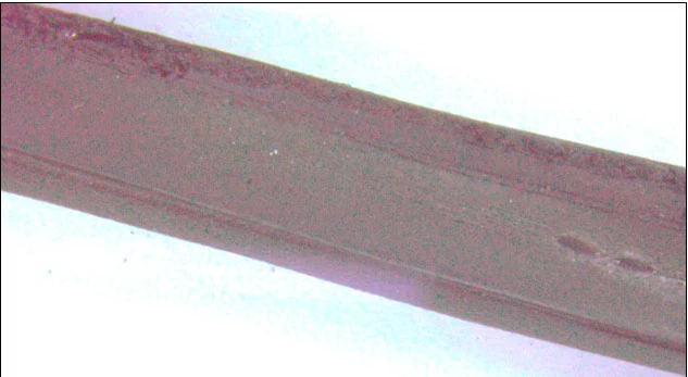 Фото 4. Внешний вид трещин на поверхности прокладки теплообменника горизонтально проходящих в толщу материала (увеличение 3.8х)