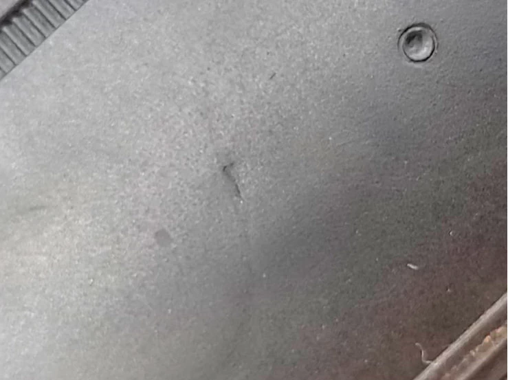 Фото 22. Повреждение на внешней боковине шины в виде вмятины (смятие, пробой, продавливание резины) внутрь неровной формы. От данной вмятины расходятся следы в виде 2-х трасс разной длины