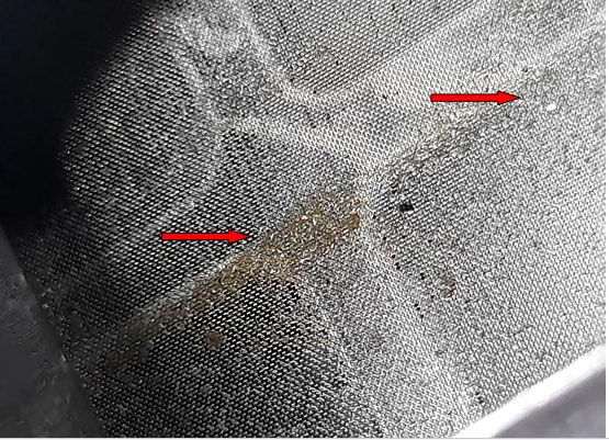 Фото 12. Фрагменты износа деталей на внешней стороне сетки фильтра (показаны красными стрелками)